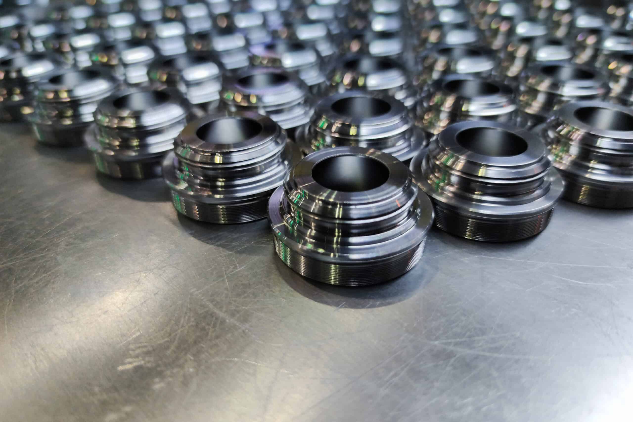 a batch of shiny metal cnc aerospace parts production - close-up with selective focus for industrial background composition